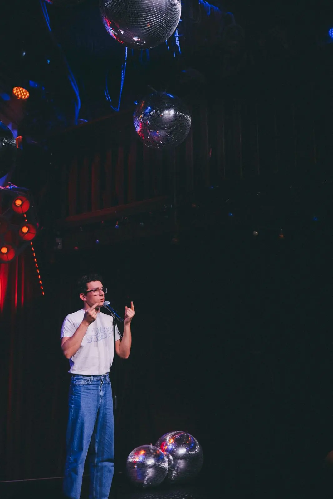 Un homme debout qui parle dans un micro sur une scène
